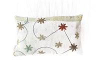 Suzani pillowcase 30x50 cm in white fabric with embroidered bows and floral stars in beige green and blue shades in boho vintage style