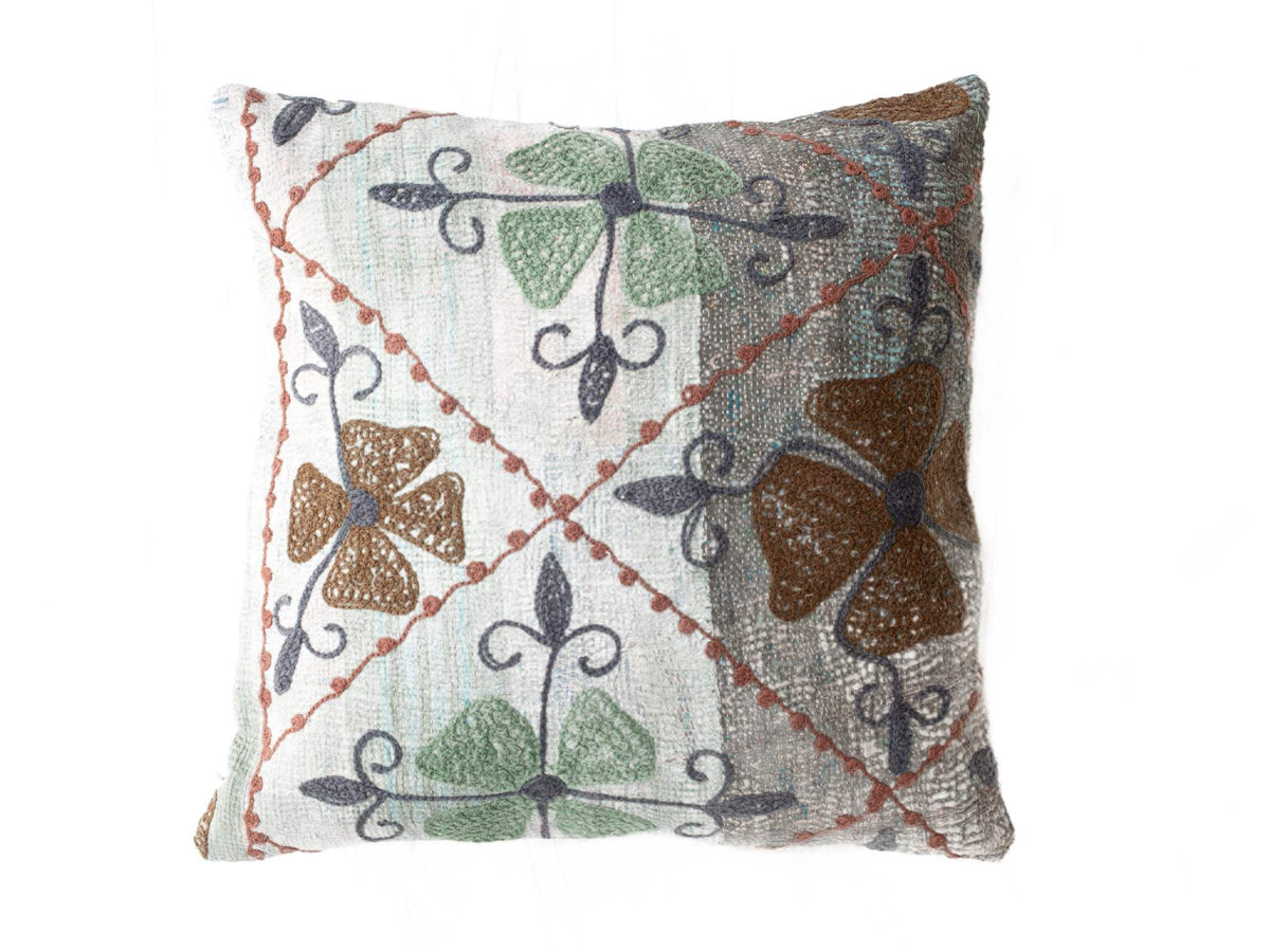 Bestickter Suzani-Kissenbezug 50x50 cm in Creme mit farbenfrohem Muster aus grünen und blauen Blumen, braun-rotem Rand und ethnischem Boho-Look.
